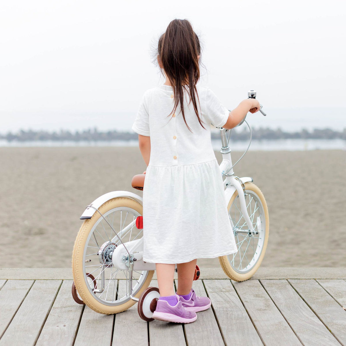 木道で自転車を押す女の子